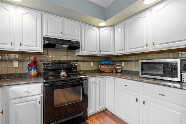 1620 Fieldstone Ln, Howards Grove, WI 53083 - kitchen featuring black range with electric cooktop, under cabinet range hood, stainless steel microwave, white cabinets, and backsplash