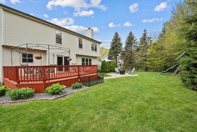 1620 Fieldstone Ln, Howards Grove, WI 53083 - rear view of property with a chimney, a yard, a wooden deck, a fire pit, and a playground