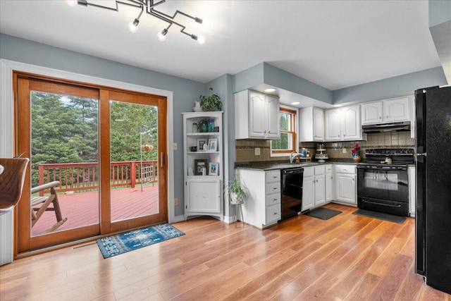 1620 Fieldstone Ln, Howards Grove, WI 53083 - kitchen featuring black appliances, white cabinets, dark countertops, under cabinet range hood, and light wood-type flooring