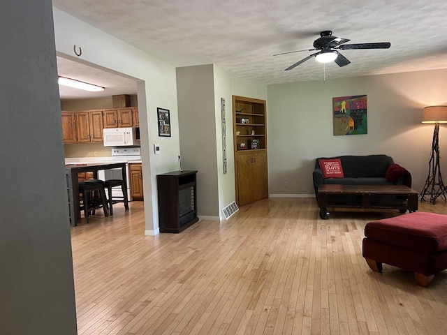 S9085 Meadowdale Rd, Prairie Du Sac, WI 53578 - living area featuring ceiling fan, light wood finished floors, a textured ceiling, and baseboards
