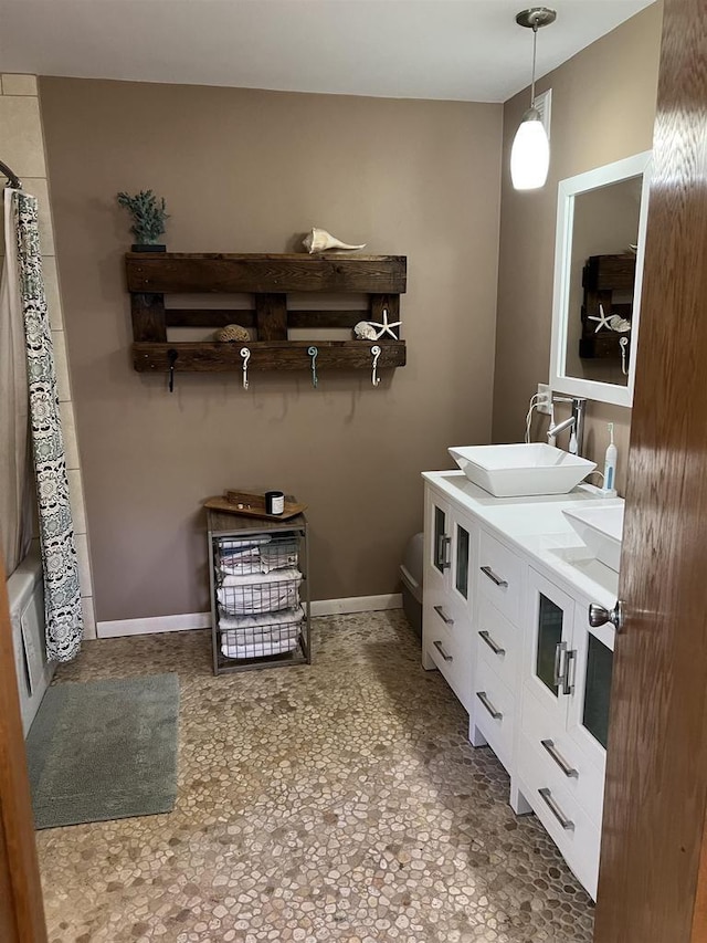 S9085 Meadowdale Rd, Prairie Du Sac, WI 53578 - bathroom featuring double vanity, toilet, a shower with shower curtain, and baseboards