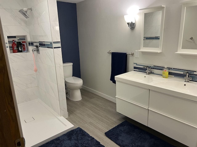 S9085 Meadowdale Rd, Prairie Du Sac, WI 53578 - full bath featuring toilet, a tile shower, double vanity, wood finished floors, and baseboards