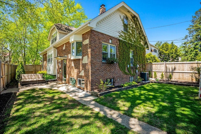 5642 N Argyle Ave, Glendale, WI 53209 - view of property exterior featuring central AC unit, brick siding, a chimney, and a patio