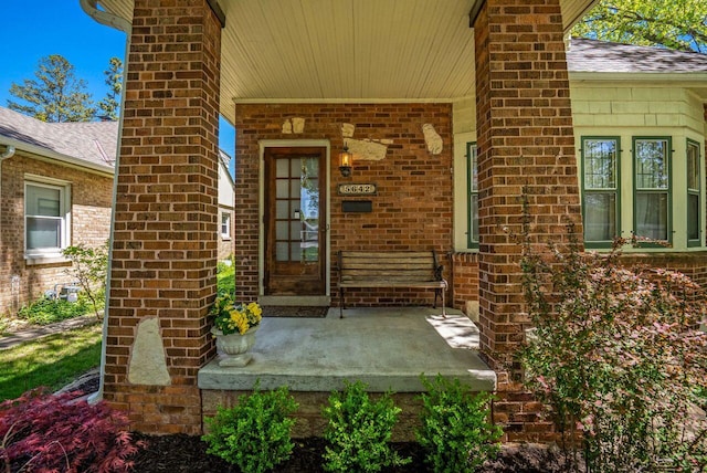 5642 N Argyle Ave, Glendale, WI 53209 - property entrance featuring a porch, a chimney, a shingled roof, and brick siding