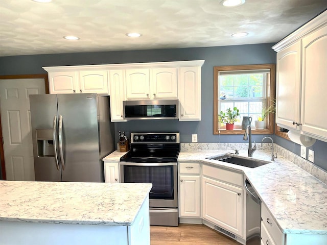 1401 E Bedford Ln, Appleton, WI 54915 - kitchen with appliances with stainless steel finishes, a sink, recessed lighting, light wood-style floors, and light stone counters