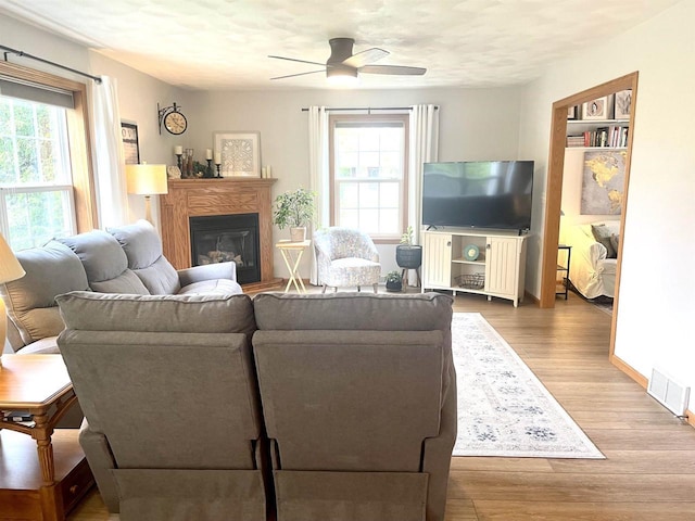 1401 E Bedford Ln, Appleton, WI 54915 - living room featuring a ceiling fan, a glass covered fireplace, wood finished floors, and baseboards