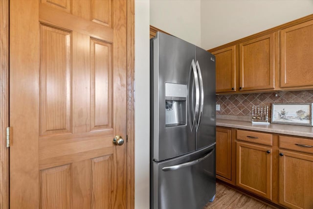 1758 Raintree Ln Unit 45, Mount Pleasant, WI 53406 - kitchen featuring stainless steel fridge, light countertops, decorative backsplash, brown cabinets, and light wood-style flooring