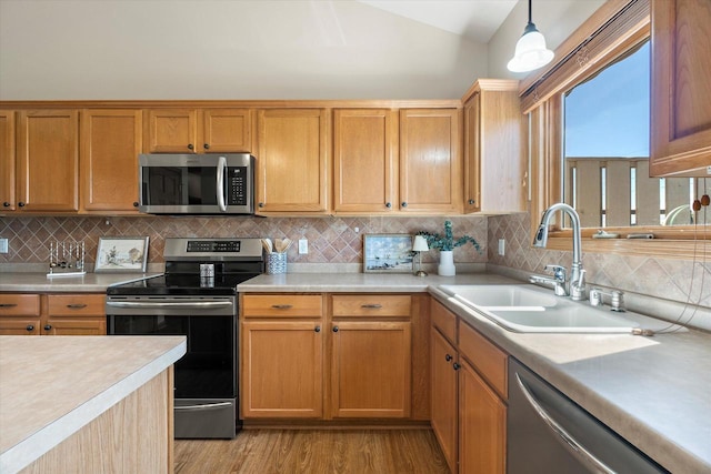 1758 Raintree Ln Unit 45, Mount Pleasant, WI 53406 - kitchen with appliances with stainless steel finishes, a sink, light countertops, light wood-type flooring, and tasteful backsplash