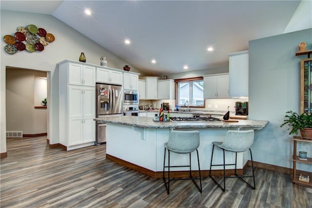 4708 Abbey Rd, Eau Claire, WI 54701 - kitchen with stainless steel appliances, vaulted ceiling, a peninsula, white cabinetry, and light stone counters