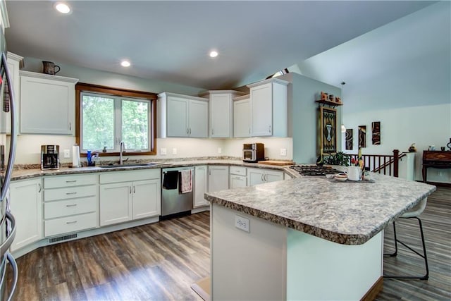 4708 Abbey Rd, Eau Claire, WI 54701 - kitchen with appliances with stainless steel finishes, a sink, a breakfast bar, dark wood finished floors, and a peninsula