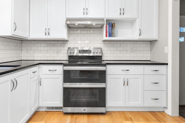 208 Edgewood Dr, Neenah, WI 54956 - kitchen featuring range with two ovens, under cabinet range hood, dark countertops, white cabinetry, and light wood-style flooring