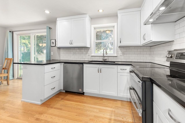 208 Edgewood Dr, Neenah, WI 54956 - kitchen featuring a sink, under cabinet range hood, appliances with stainless steel finishes, a peninsula, and white cabinetry