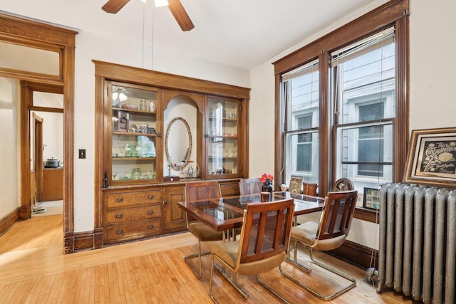 310 E Smith St Unit 312, Milwaukee, WI 53207 - dining area featuring radiator heating unit, light wood finished floors, ceiling fan, and baseboards