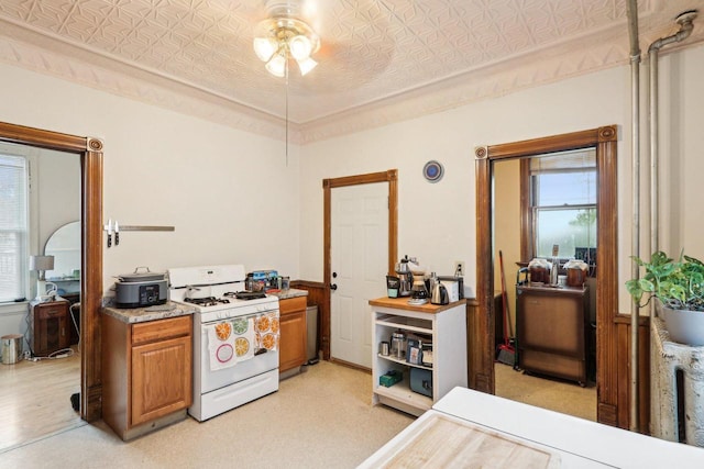 310 E Smith St Unit 312, Milwaukee, WI 53207 - kitchen featuring white range with gas stovetop, an ornate ceiling, a ceiling fan, brown cabinetry, and light countertops