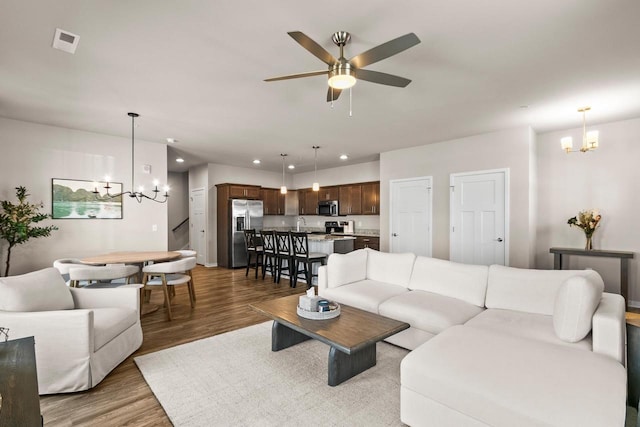 4857 Suelo Rd, Fitchburg, WI 53711 - living area featuring a chandelier, wood finished floors, recessed lighting, ceiling fan, and baseboards