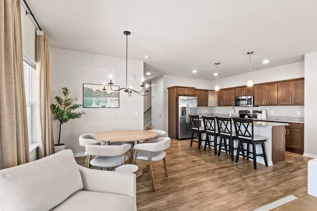 4857 Suelo Rd, Fitchburg, WI 53711 - dining area with a chandelier, wood finished floors, recessed lighting, and baseboards