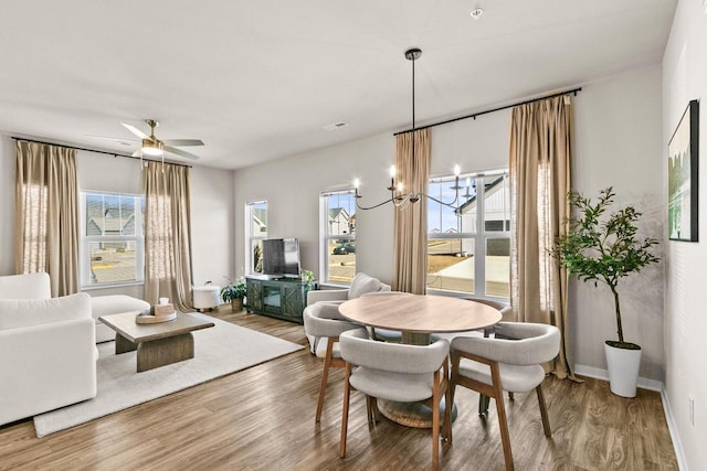 4857 Suelo Rd, Fitchburg, WI 53711 - dining area featuring healthy amount of natural light, wood finished floors, a ceiling fan, and a chandelier