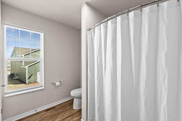 4857 Suelo Rd, Fitchburg, WI 53711 - full bath featuring toilet, wood finished floors, baseboards, and a shower with curtain