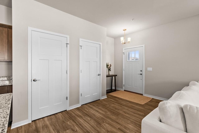4857 Suelo Rd, Fitchburg, WI 53711 - foyer with dark wood finished floors, a chandelier, and baseboards
