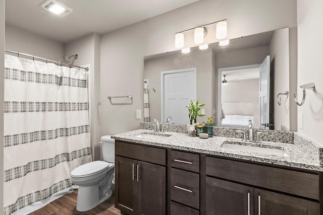 4857 Suelo Rd, Fitchburg, WI 53711 - full bath featuring wood finished floors, ceiling fan, toilet, double vanity, and connected bathroom