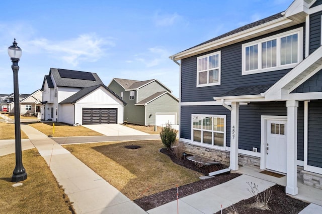 4857 Suelo Rd, Fitchburg, WI 53711 - view of front of home with concrete driveway, a residential view, a garage, stone siding, and a front yard