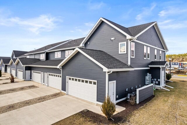 4857 Suelo Rd, Fitchburg, WI 53711 - view of side of home featuring driveway, roof with shingles, and a garage
