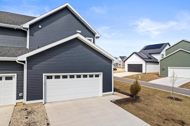 4857 Suelo Rd, Fitchburg, WI 53711 - view of property exterior featuring a shingled roof, concrete driveway, and a garage