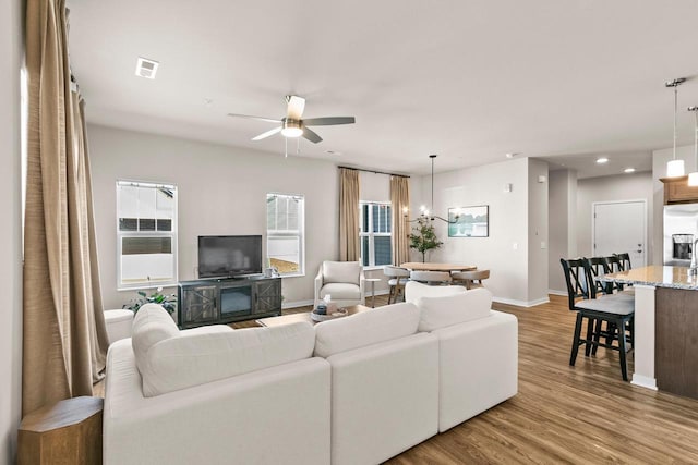 4857 Suelo Rd, Fitchburg, WI 53711 - living room featuring a ceiling fan, wood finished floors, baseboards, a chandelier, and recessed lighting