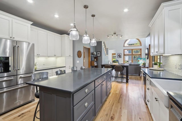 10 Prairie Hill Ct, Madison, WI 53719 - kitchen featuring stainless steel appliances, dark countertops, white cabinets, decorative backsplash, and recessed lighting