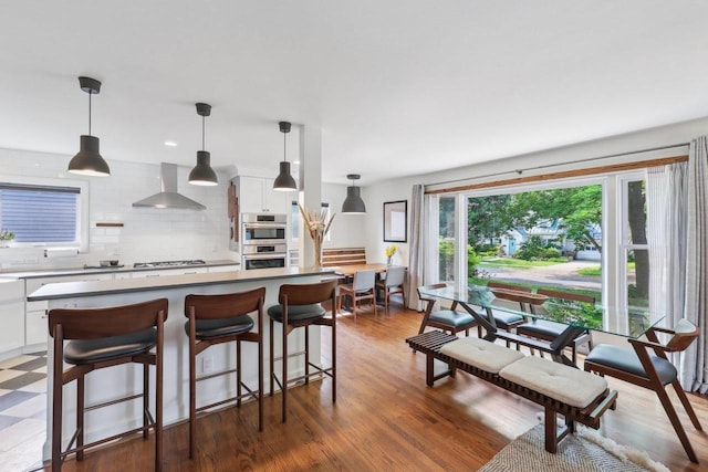3910 Birch Ave, Madison, WI 53711 - kitchen with wall chimney exhaust hood, double oven, decorative backsplash, and white cabinets
