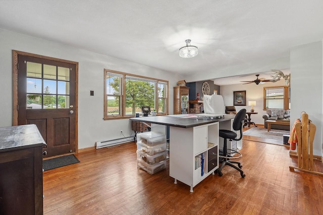 N3504 State Rd 80, Elroy, WI 53929 - kitchen with a kitchen breakfast bar, an office area, wood finished floors, a baseboard radiator, and dark countertops