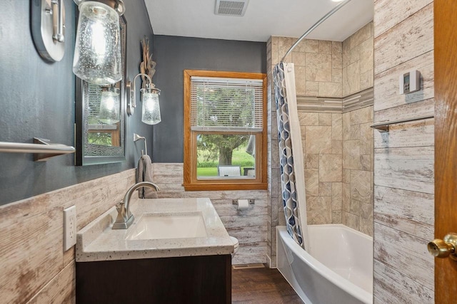 N3504 State Rd 80, Elroy, WI 53929 - bathroom with shower / bath combo with shower curtain, tile walls, vanity, wood finished floors, and a wainscoted wall