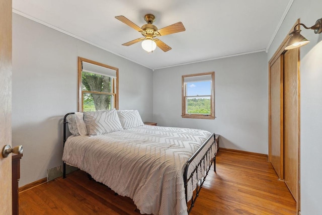 N3504 State Rd 80, Elroy, WI 53929 - bedroom featuring light wood-style floors, crown molding, baseboards, ceiling fan, and a closet