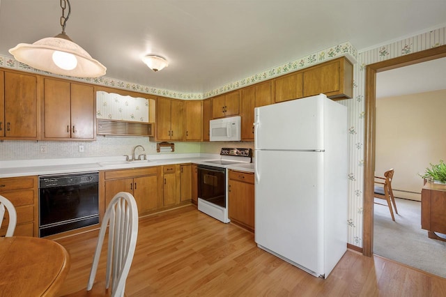 108 S Clay St, De Pere, WI 54115 - kitchen with white appliances, a sink, light wood-type flooring, light countertops, and a baseboard heating unit