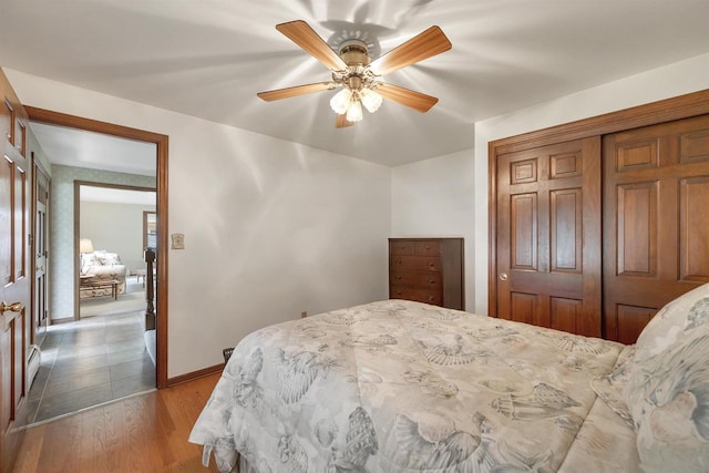 108 S Clay St, De Pere, WI 54115 - bedroom featuring wood finished floors, a closet, baseboards, ceiling fan, and a baseboard heating unit