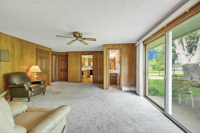 108 S Clay St, De Pere, WI 54115 - living area featuring a baseboard radiator, carpet flooring, wood walls, and a ceiling fan