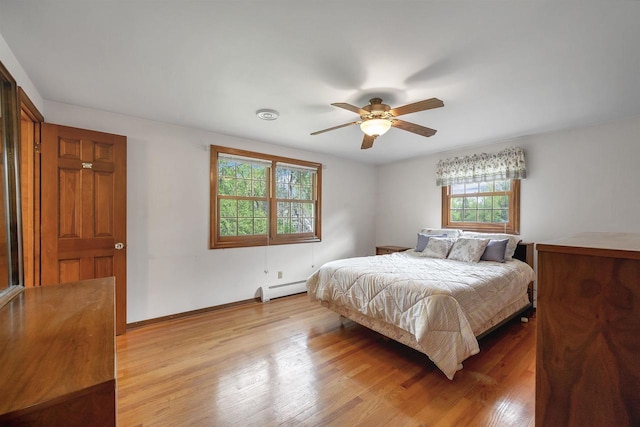 108 S Clay St, De Pere, WI 54115 - bedroom featuring a baseboard radiator, light wood finished floors, baseboards, and ceiling fan
