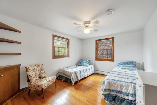 108 S Clay St, De Pere, WI 54115 - bedroom with baseboard heating, wood finished floors, and a ceiling fan