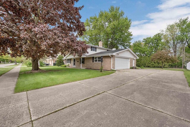 108 S Clay St, De Pere, WI 54115 - view of front facade with a garage, brick siding, a front yard, concrete driveway, and a chimney