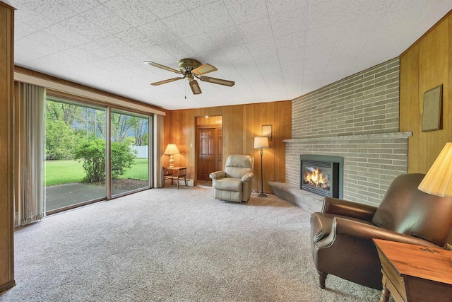 108 S Clay St, De Pere, WI 54115 - carpeted living room featuring wooden walls, a ceiling fan, and a fireplace
