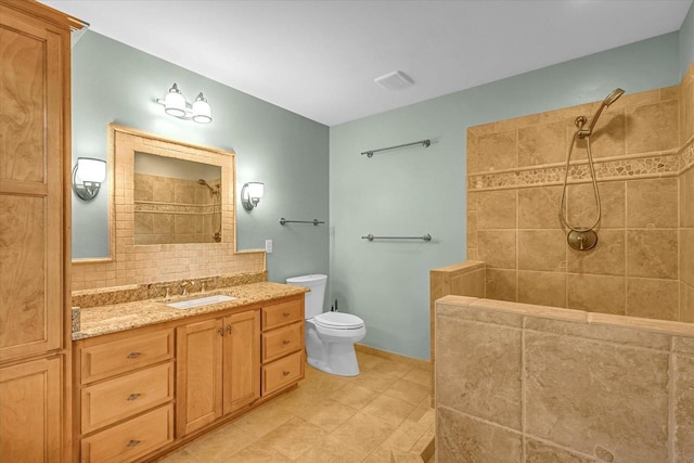 N74W28801 Zimmers Xing, Hartland, WI 53029 - full bathroom featuring toilet, a tile shower, vanity, backsplash, and tile patterned floors