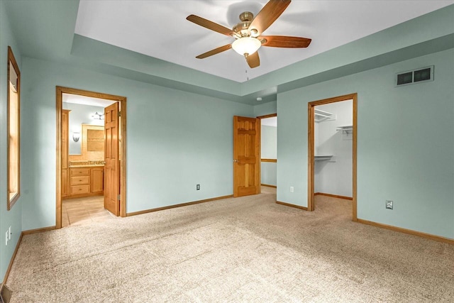 N74W28801 Zimmers Xing, Hartland, WI 53029 - unfurnished bedroom featuring light colored carpet, a spacious closet, baseboards, and ensuite bath