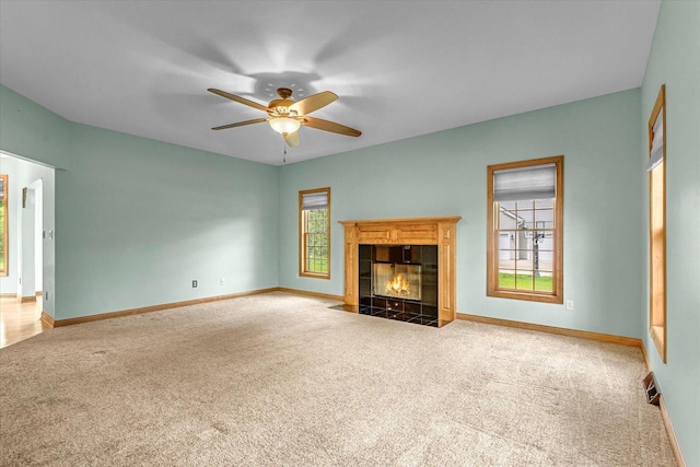 N74W28801 Zimmers Xing, Hartland, WI 53029 - unfurnished living room featuring carpet, a ceiling fan, a tile fireplace, and baseboards