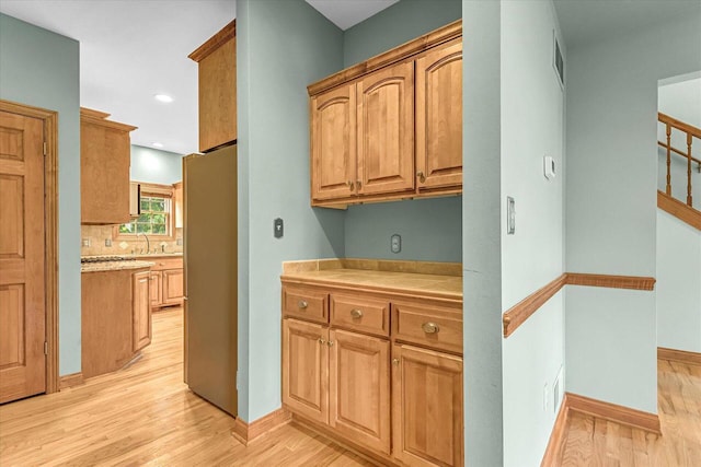 N74W28801 Zimmers Xing, Hartland, WI 53029 - kitchen with freestanding refrigerator, light wood-style floors, tile countertops, baseboards, and recessed lighting