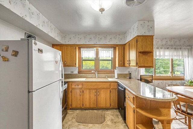 1416 Lake Dr, South Milwaukee, WI 53172 - kitchen featuring open shelves, freestanding refrigerator, wallpapered walls, a sink, and a peninsula