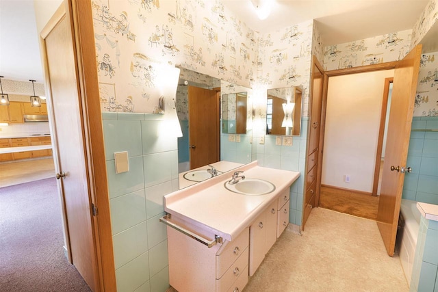 3023 Park Ave, Beloit, WI 53511 - bathroom featuring wallpapered walls, tile walls, vanity, and wainscoting
