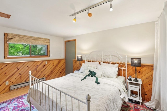 3604 Glenn Ln, Middleton, WI 53562 - bedroom with wood walls, baseboard heating, a wainscoted wall, track lighting, and wood finished floors