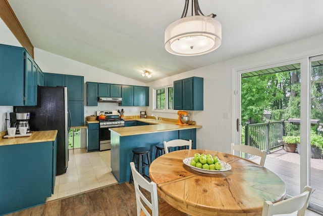 3604 Glenn Ln, Middleton, WI 53562 - kitchen with stainless steel range with gas stovetop, a peninsula, lofted ceiling, freestanding refrigerator, and light wood finished floors