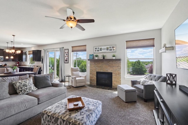 417 Champlain Dr, Johnson Creek, WI 53038 - living room featuring a stone fireplace, carpet floors, a ceiling fan, and a chandelier