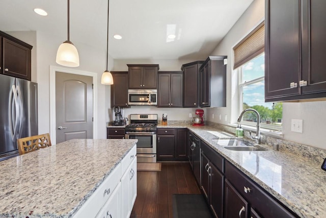 417 Champlain Dr, Johnson Creek, WI 53038 - kitchen with appliances with stainless steel finishes, a sink, dark brown cabinets, light stone counters, and recessed lighting